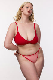 Plus size model wearing red g-string and bralette, front view
