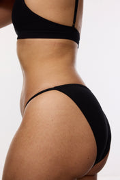 Model wearing black cotton bikini brief underwear, side view