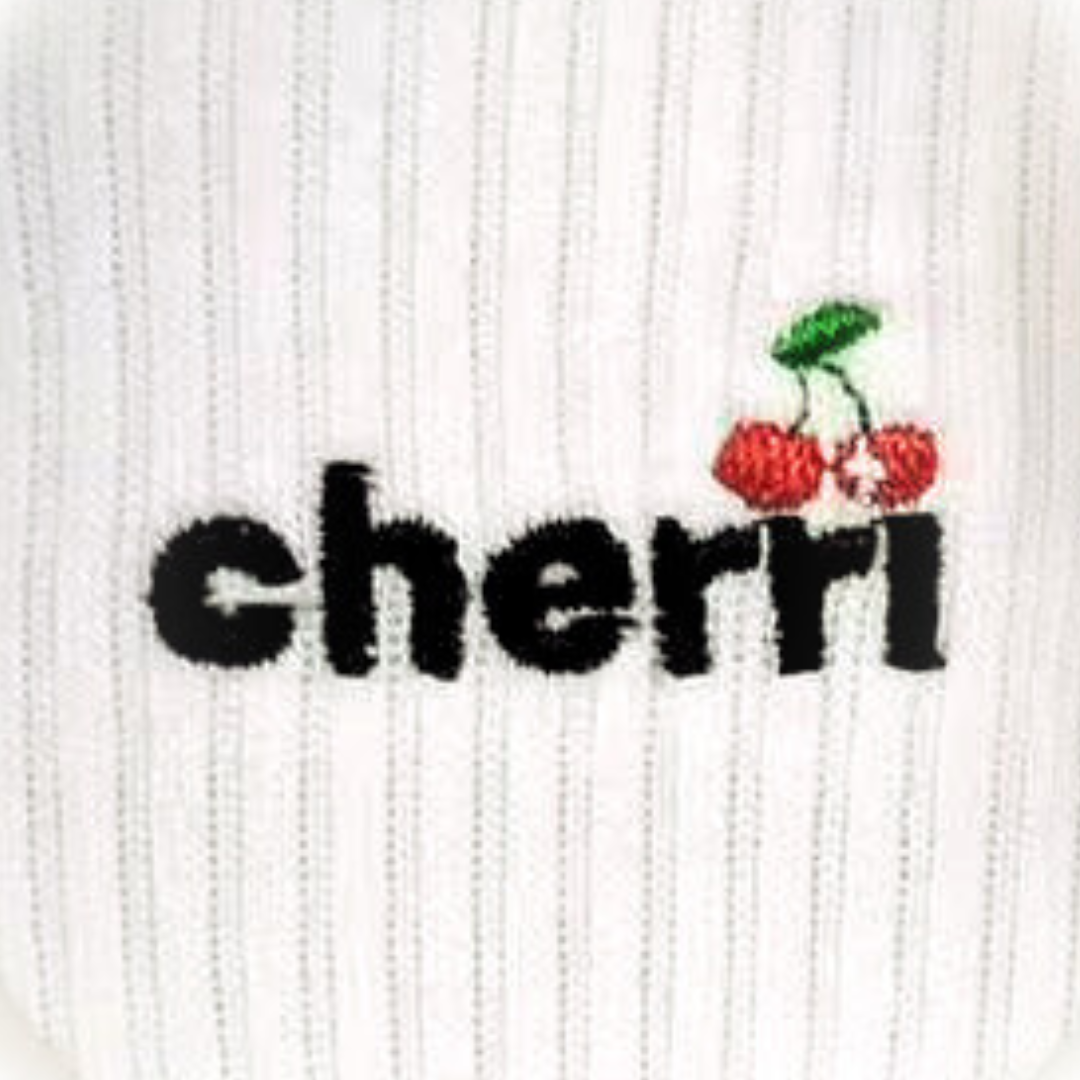 Cherri Ruffle Trim Sock detail - close-up of cherri logo embroidery with cherry graphic on white ribbed sock fabric