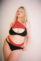 Model wearing black mid-rise thong artistically layered over a red mid-rise thong